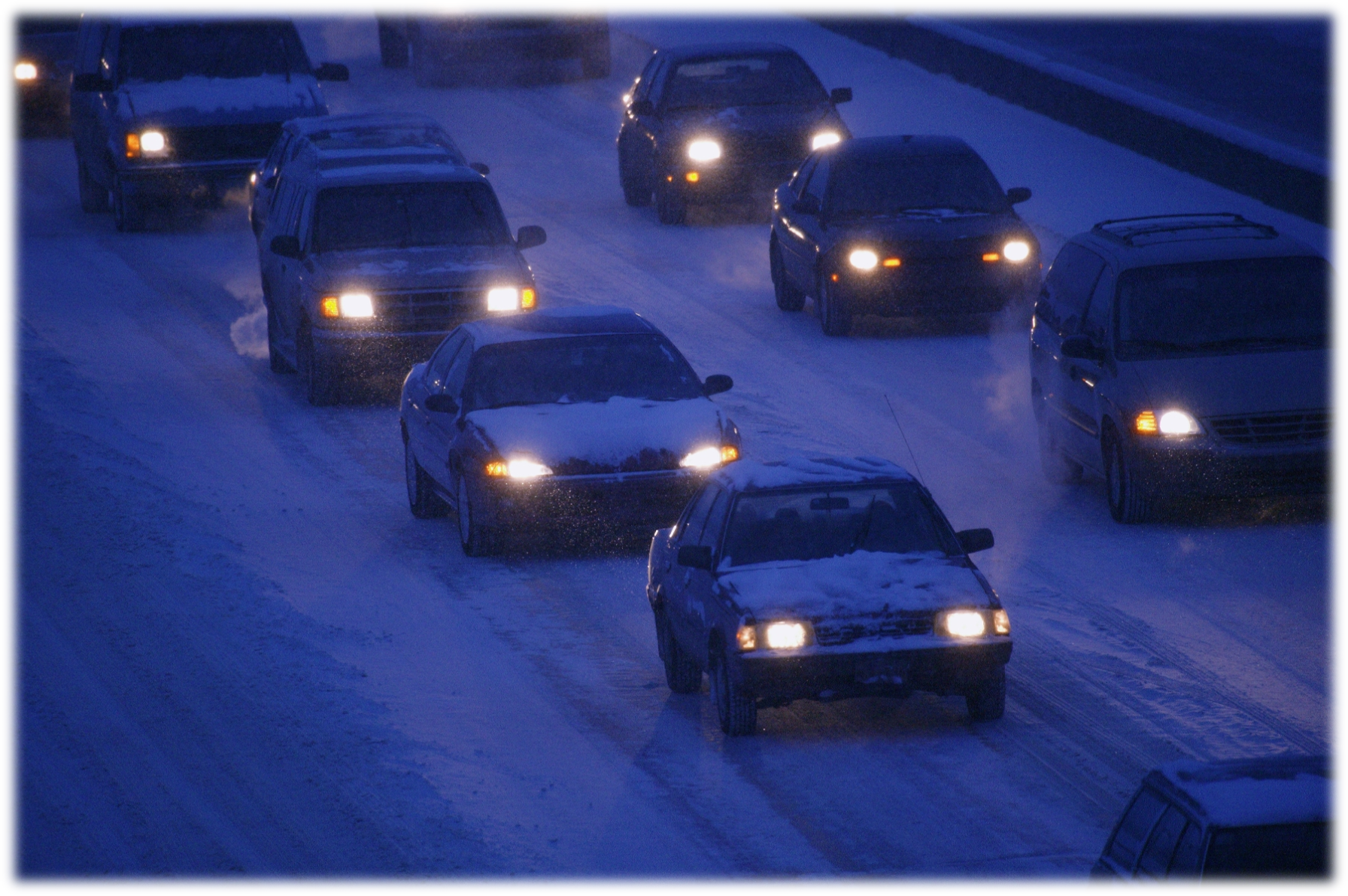 Link to Driving Safety - Vehicles on snowy dark highway with lights on.